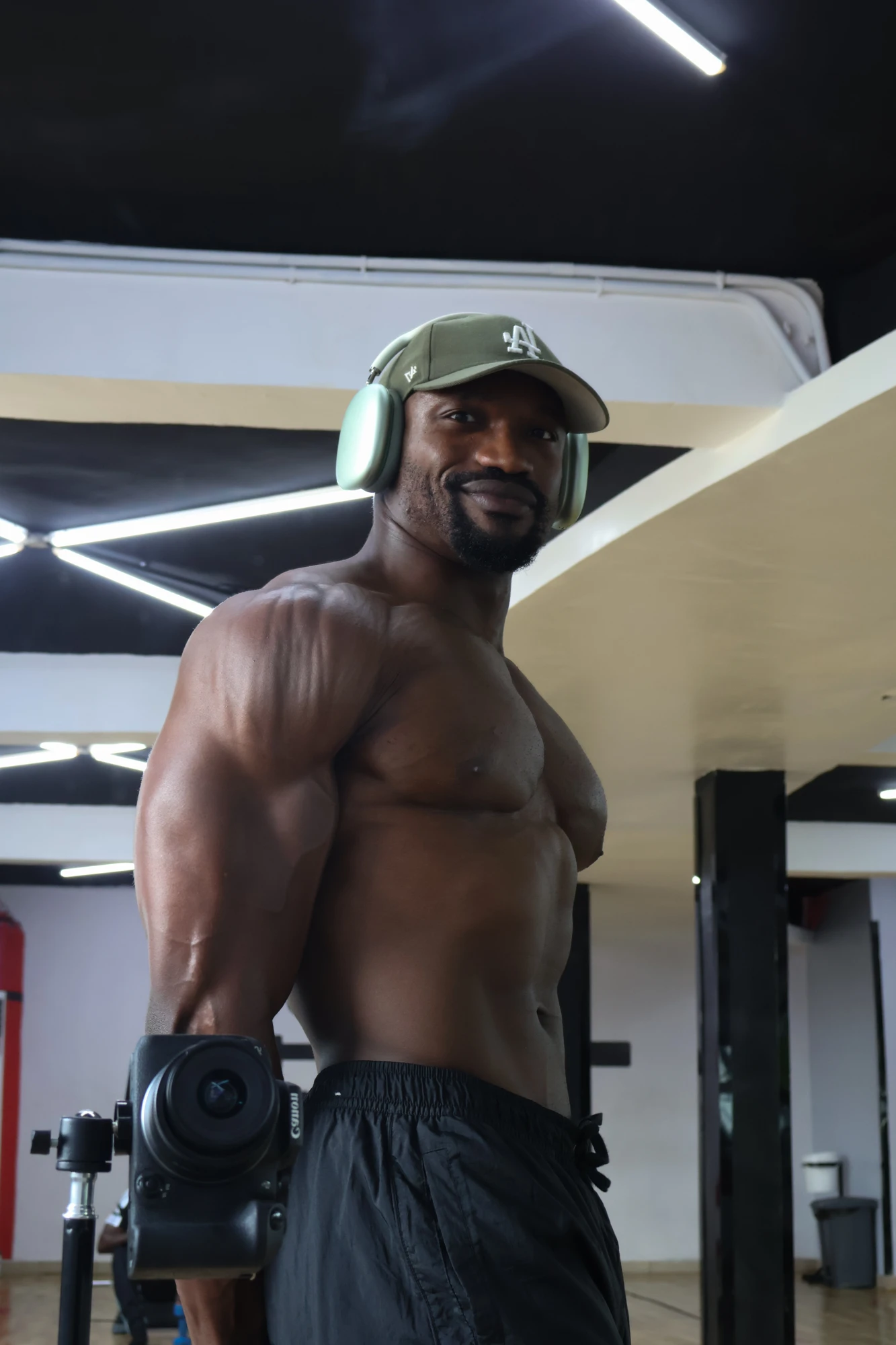 Samuel in the gym, wearing a cap and headphones